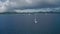 Drone whirls over a yacht in the sea on the horizon shore with hills and clouds Saint Lucia