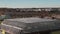 Drone wide shot of an industrial roof. Roofers installing a new roof on an industrial building or warehouse.