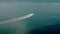 Drone wide view of a white boat sailing to the blue sea. moving at high speed.