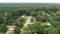 Drop down aerial flight showing green trees street neighborhood