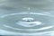 A drop of water hovering in the air before hitting a water surface, which will cause a beautiful splash, close-up photo