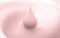 Droplet of pink milk on pink background