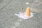 Dropped ice cream cup on the ground asphalt pavement and melted from the heat view from above