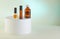 Dropper Bottle - Amber Glass of perfume, shower gel, unlabeled bottles on white podium