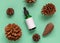 Dropper Bottle near pine cones on blue top view. Brand packaging mockup