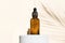 A dropper bottle of serum or liquid collagen on a beige background with a shadow from thin palm leaves. The concept of