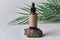 Dropper brown glass bottle on white background with green palm leaves