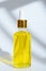 Dropper glass bottle with yellow cosmetic oil on white background
