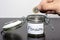 Dropping one pound coin into jar for Pension