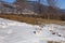 Drops of clean drinking water from Lake Baikal are splashed from a metal aluminum mug on the snow.