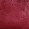 Drops of rain on red glass background. Natural Pattern of raindrops. Rain in the city.