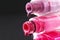 drops of red bearded pink nail polish flow from the bottle of the bottle on a black dark background with a copyspace