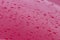 Drops of water on the red car roof, nature background