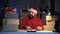 Dropshipping owner male Hindu Santa Claus works at night in his home office, with a boxes before shipping to a customer