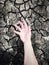 Drought and famine concept of lifeless human hand with parched earth