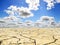 Drought landscape against bright blue sky with clouds