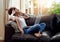 Drown out the world, turn up the music. a young woman relaxing on the sofa and listening to music on her laptop.