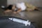 Drug addict and syringe on floor