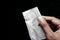 drug addiction concept with hand holding heroine packet on black backgrund