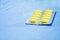 Drug yellow or treatment medication in packages plastic pill. on blue fabric table select focus with shallow depth of field with