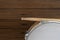 Drum and drum stick on wooden table background, top view, music concept