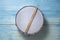 Drum stick and drum on the blue table background, top view, music concept