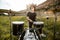 Drummer in black hat rehearses in the open air. He plays drums in the grass near the old castle