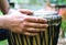 Drummer hands playing the ethnic djembe drum.