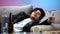 Drunk young man sleeping on couch after night long party, idle life, hangover