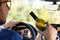 Drunken male driving a car with a bottle of alcohol in his hand