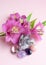 Druse amethyst in the shape of a heart, rock crystal, rose quartz and alstroemeria flowers on a pink background