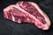 Dry-aged Raw T-bone or porterhouse beef marbled meat prime steak, on black stone background