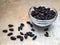 Dry barberries in a bowl on grey concrete table top