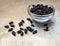 Dry barberries in a bowl on grey concrete table top