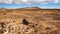 Dry barren plain with mountain in the distance