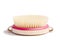 Dry body massage brush on white background at sunny day. Tool for smooth and soft skin.