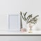 Dry branch of eucalyptus in a white figured earthenware vase. A figurine of a pink bird and a cup on the table. Scandinavian style