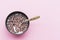 Dry breakfast with milk in plate with spoon pattern on pink background top view