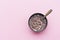 Dry breakfast with milk in plate with spoon pattern on pink background top view. Objects on a simple background