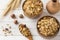 Dry Breakfast of oat flakes, granules and nuts. Muesli in a deep wooden plate.