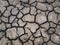 Dry and broken clay ground during drought season, concept of global warming problem. Cracked and barren soil texture background.