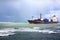 Dry cargo ship, bulk carrier vessel with containers aboard enters the sea harbor in a seaport