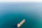 The dry cargo vessel enters the port with the help of tugs. Photo from a helicopter. Bird's-eye view