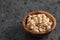 Dry cashew nuts in wood olive bowl on concrete background with copy space