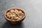 Dry cashew nuts in wood olive bowl on concrete background with copy space