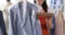 Dry cleaning administrator holds out suit with documents for signature