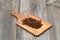 Dry cloves in wooden scoop isolated on wooden background with clipping path. Top view. Flat lay. selective focus