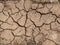 Dry cracked clay soil on the ground in the summer during the heat. Textured and geometrical pattern in nature