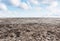 Dry cracked drought ground with blue sky and white clouds