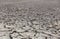 Dry cracked mud desert like gray background, scorched earth with selective focus